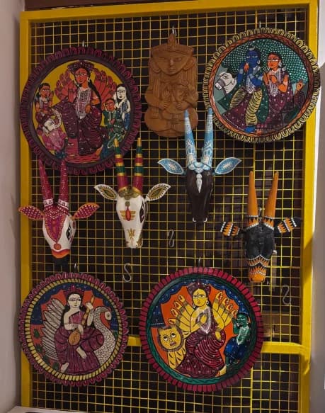 Patachitra plates from Pingla with Udaipur wood carvings on a display wall